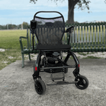 Matrix Ultra 2 Power wheelchair on a concrete surface with a park bench and grass in the background